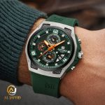 A man wearing a Naviforce 8051T Green Silver Silicone Chronograph watch with a green dial and orange accents on his wrist.