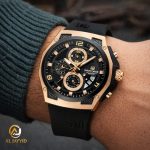 A close-up of the Naviforce 8051T Black Rose-Gold Chronograph Watch being worn on a man's wrist against a dark sweater.