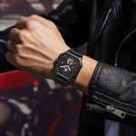 A man wearing a black leather jacket with the POEDAGAR 628 men's belt watch on his wrist.