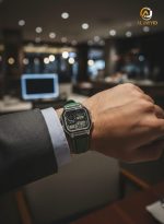 A man wearing the Casio AE-1200WHL-5AV Men's Watch with a green strap on his wrist, paired with a formal suit jacket.