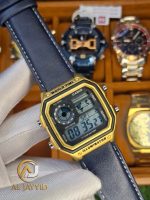 A person holding a Casio AE-1200WHL-5AV men's watch. The watch has a gold-tone case and a dark leather strap.