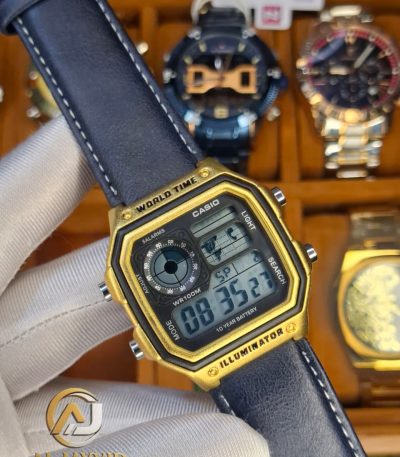 A person holding a Casio AE-1200WHL-5AV men's watch. The watch has a gold-tone case and a dark leather strap.