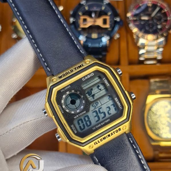 A person holding a Casio AE-1200WHL-5AV men's watch. The watch has a gold-tone case and a dark leather strap.