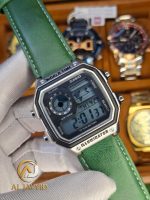 A person wearing a white glove holding a Casio AE-1200WHL-5AV men's watch with a distinctive green leather strap.
