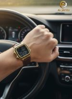 A man wearing the Casio AE-1200WHL-5AV watch with a gold-colored case and a brown strap while holding a car steering wheel.