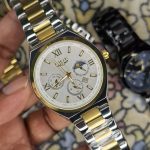 A close-up, top-down shot of a gold-toned LIGE luxury chronograph watch being held by a hand