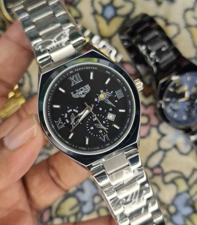 A close-up, top-down shot of a gold-toned LIGE luxury chronograph watch being held by a hand