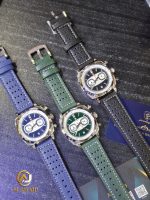 A silver Poedagar 838 luxury sports chronograph watch with a forest green dial and a matching textured green leather strap, displayed in a branded box. The watch features three sub-dials, a date window, and a silver tachymeter bezel.