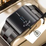 A black Poedagar 857 men's wristwatch with a rectangular case and a unique rotating dial display, resting on a white cushion inside a watch box.